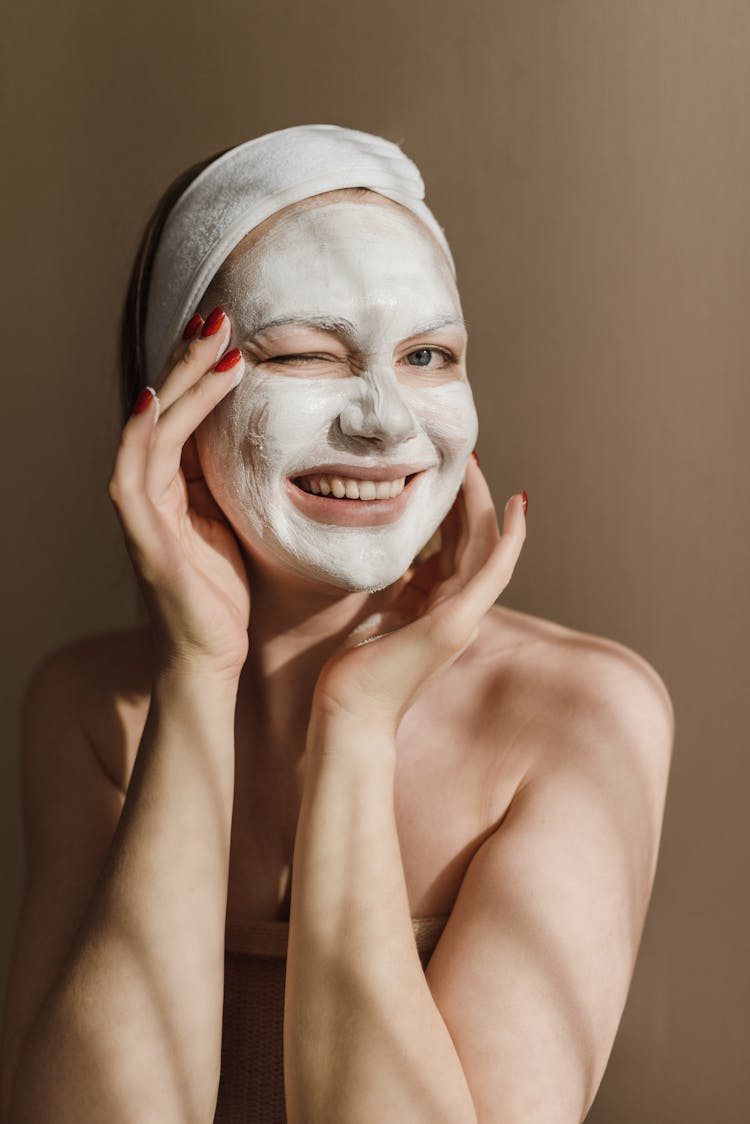 Woman Covering Her Face With A Facial Treatment Mask