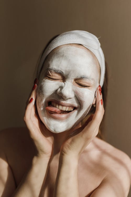 Free Woman With White Facial Cream with Tongue Out Stock Photo