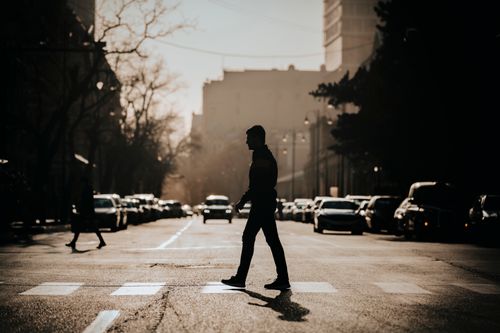 Free A silhouette of a man crossing a city street at sunset in Baku, Azerbaijan. Stock Photo