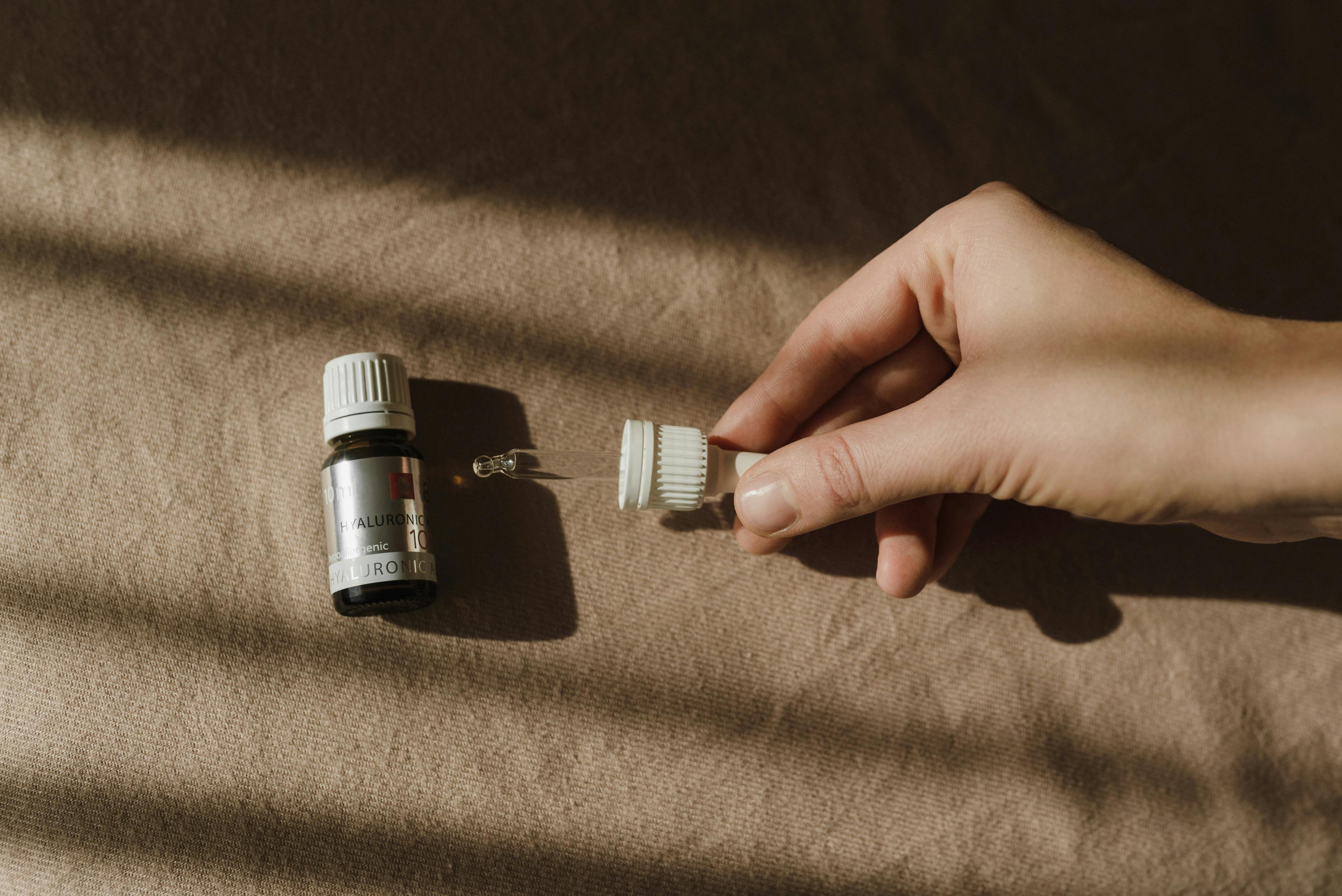 Close-up of a Korean essence being patted onto skin, showing its lightweight, translucent texture and hydrating effect.