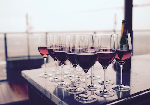 Free Wine Glass With Red Liquid on Black Table Stock Photo