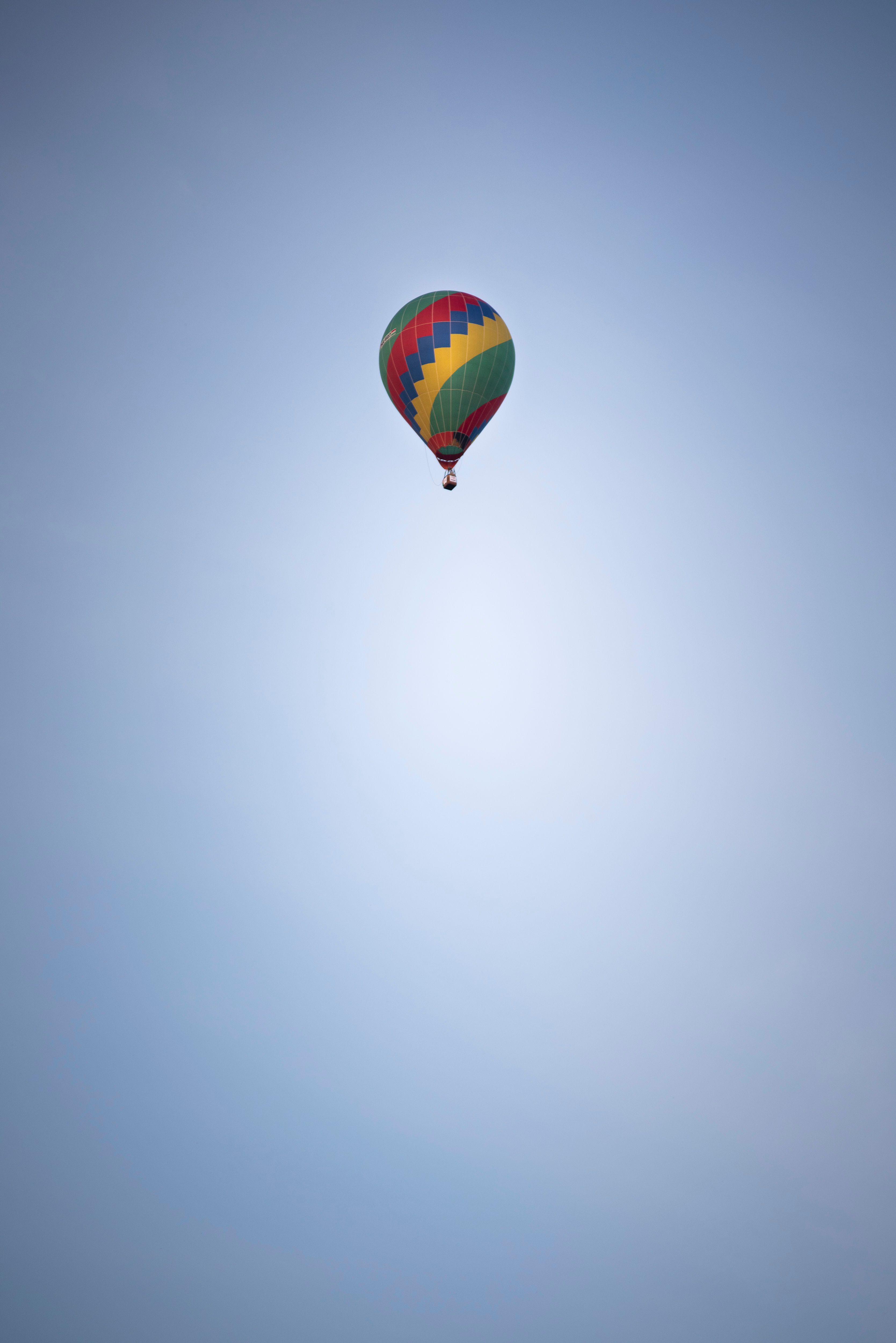 Aerostat with colorful ornament flying in light sky · Free Stock Photo