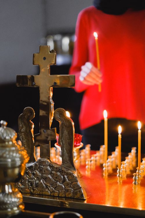 Free Intricate altar with candles and person in a red garment during a church vigil. Stock Photo
