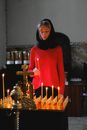 Woman in Red Turtleneck Long Sleeve Shirt Standing Near Candles