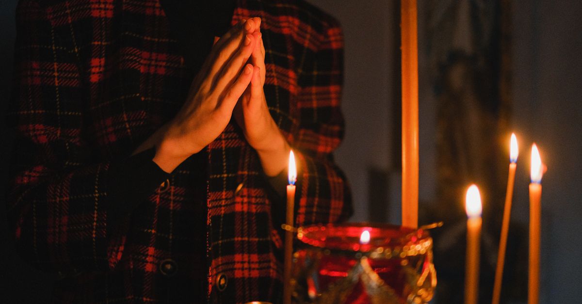 Young woman praying with candle in a quiet modern setting