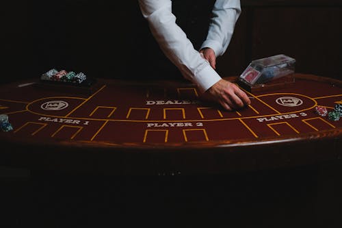 Person in White Pants and White Long Sleeve Shirt Playing Game Board