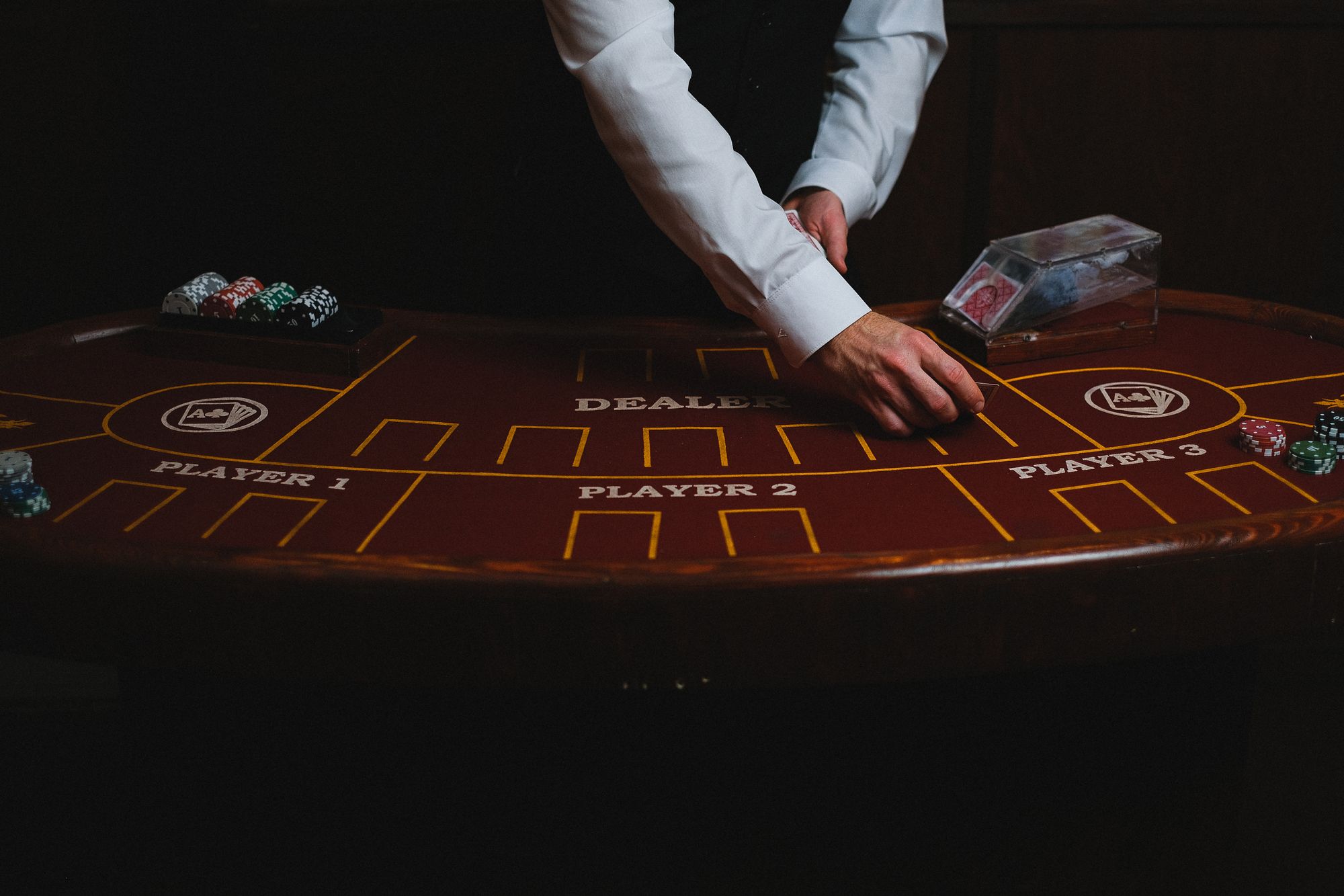 A dealer working a dimly lit card table