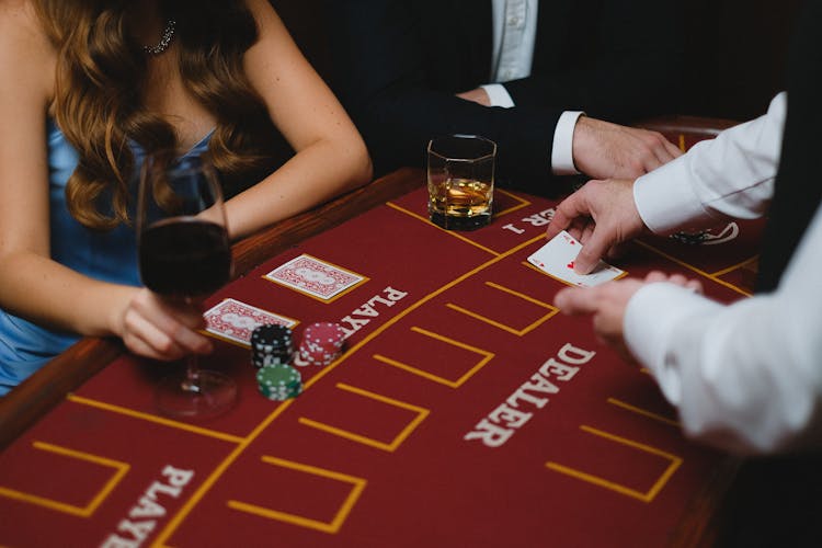 A Card Dealer Holding A Card In Front Of The Players