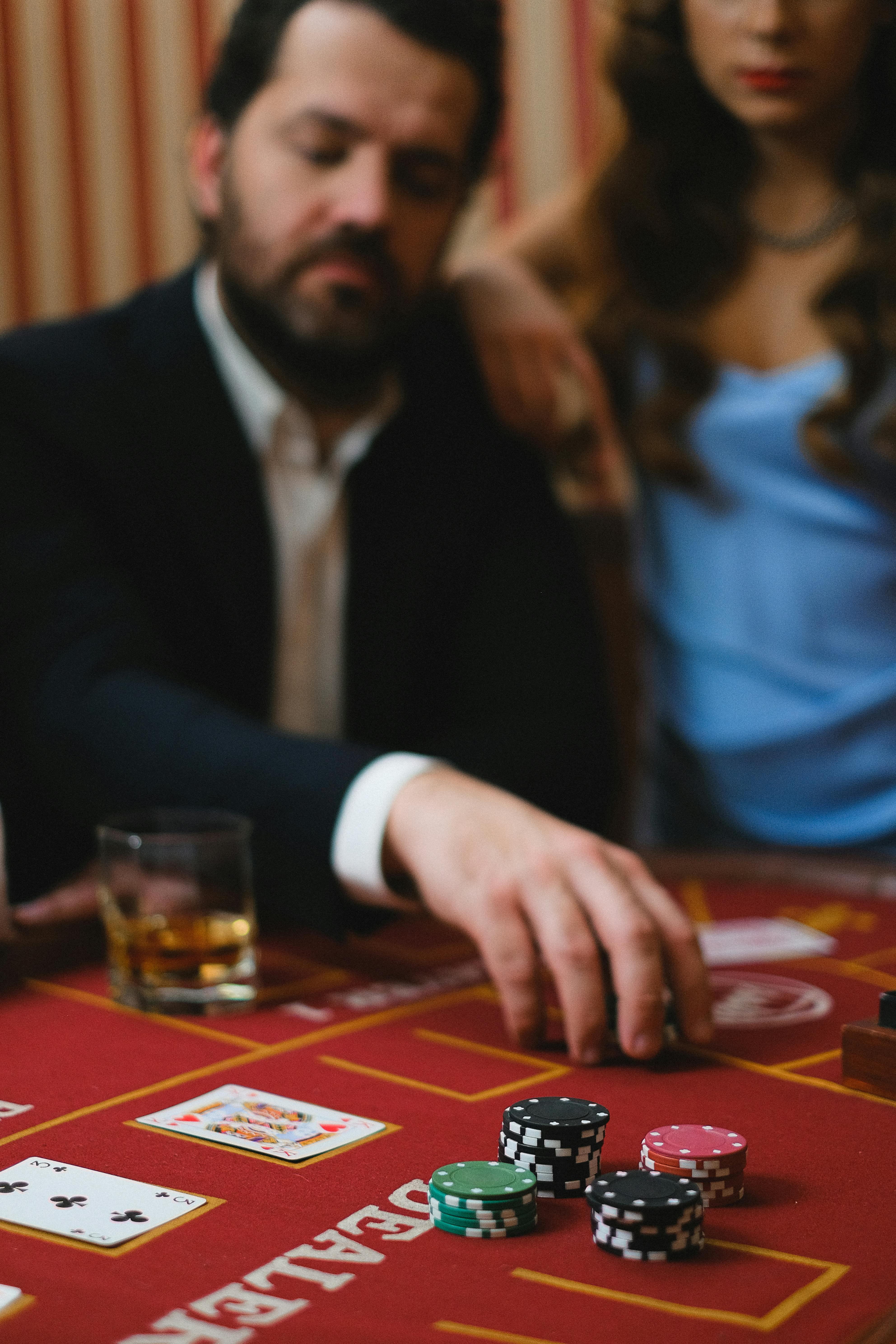 man in black suit jacket playing poker beside woman