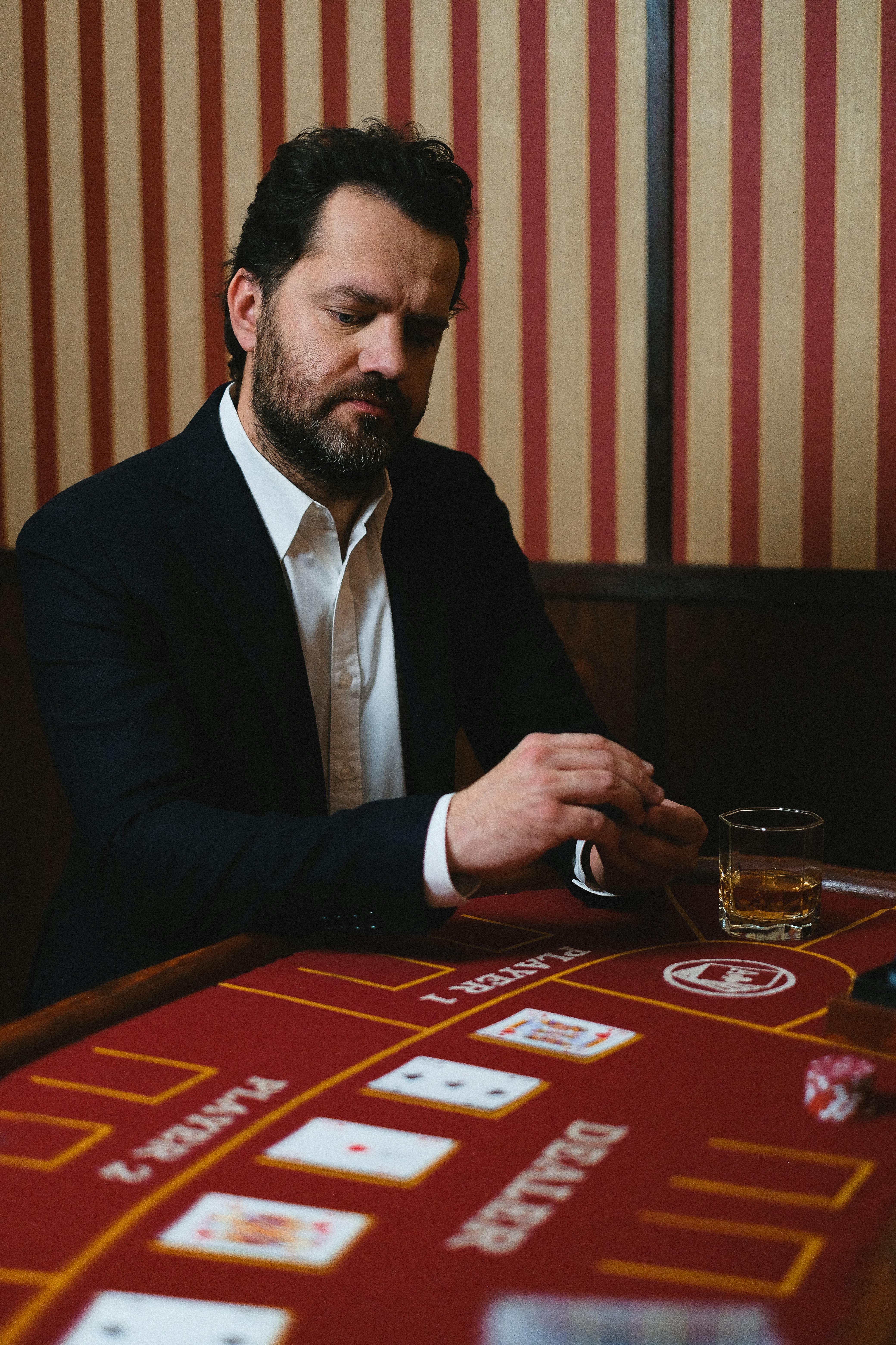 man in black suit jacket playing poker in a casino