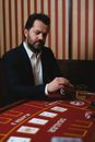 Man in Black Suit Jacket Playing Poker in a Casino