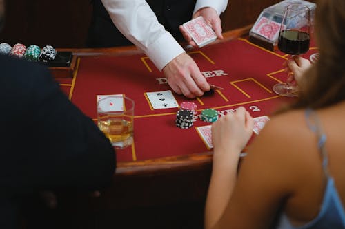 Person Dealing Cards on a Poker Table