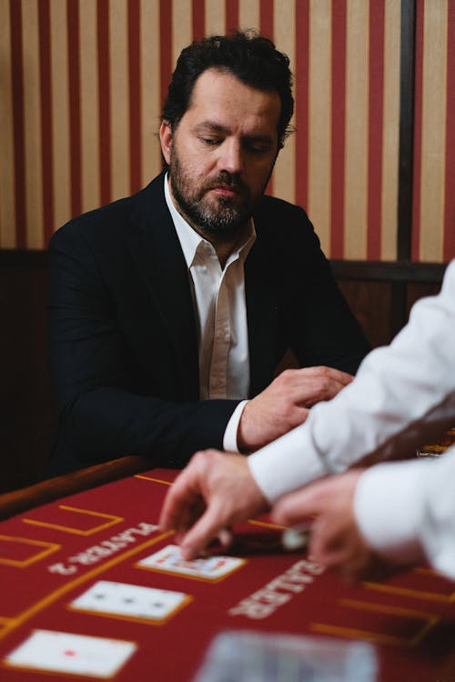 Man Looking at Cards Placed on a Poker Table