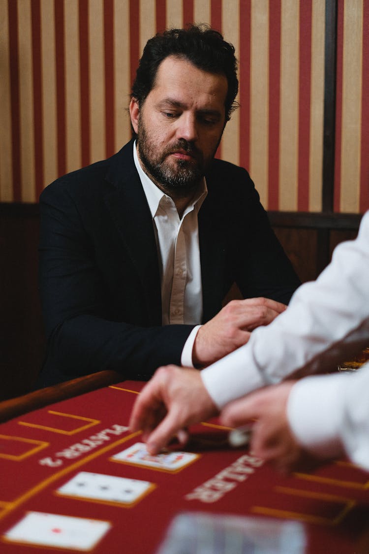 Man Looking At Cards Placed On A Poker Table