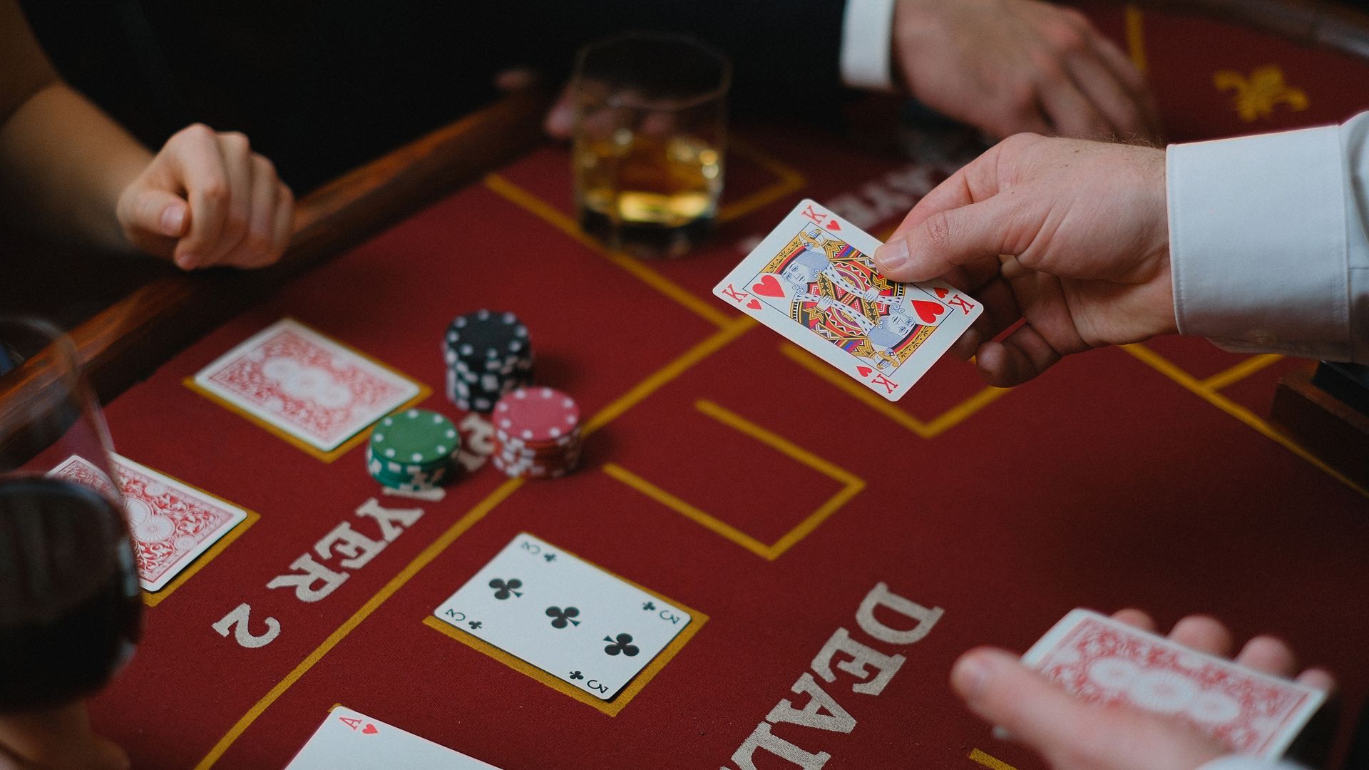 Modafinil for Poker Players: The Ultimate Guide Close-up view of a casino game with cards and chips on the table, featuring player interaction — modafinil for poker players