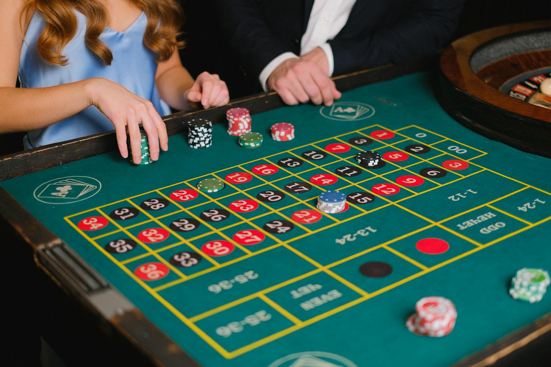 Captivating scene of a casino roulette table with gamblers placing their bets.