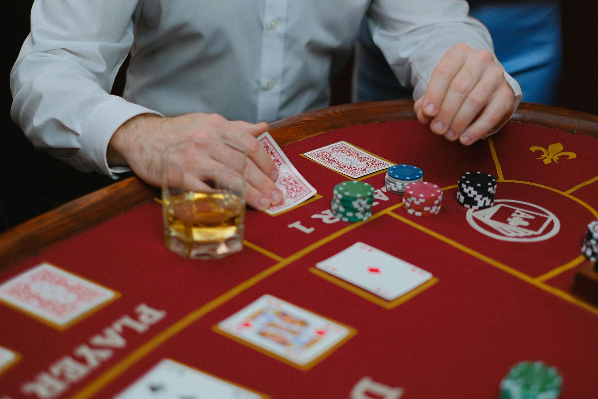 Intense poker game with cards and chips on a red casino table, creating a thrilling atmosphere.