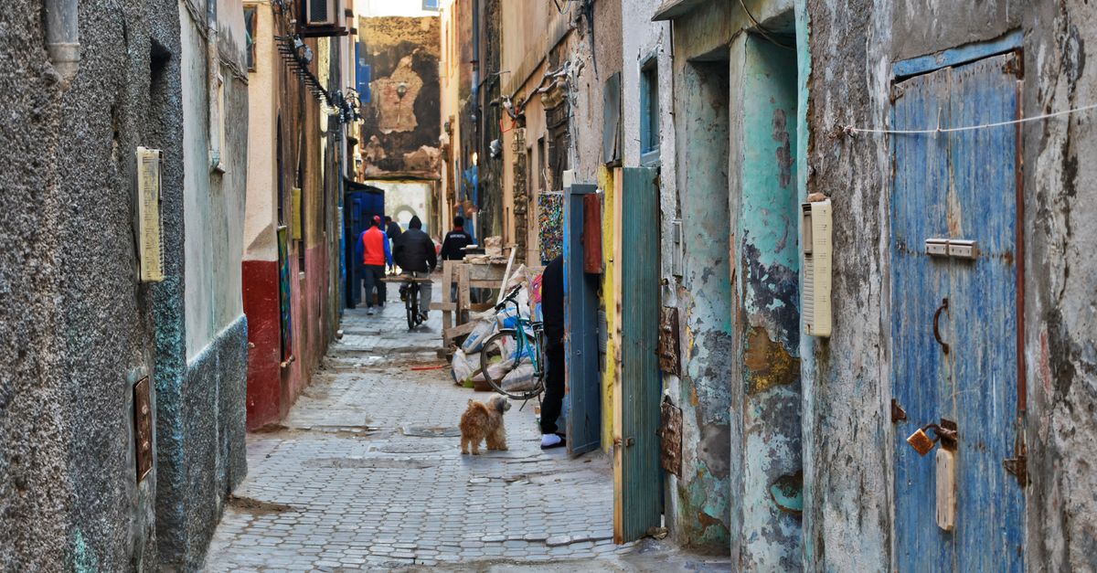 Historic Essaouira alleyway with colorful doors and local life in Morocco.