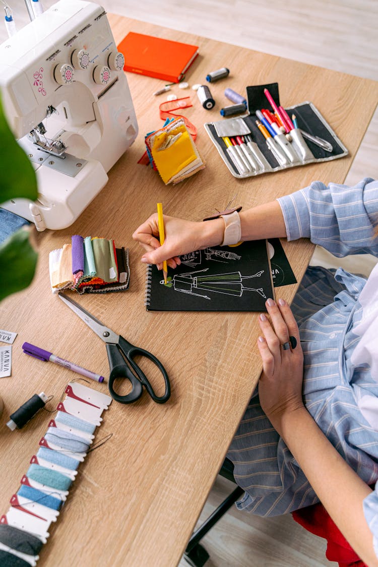 Designer Drawing Sketches On Table