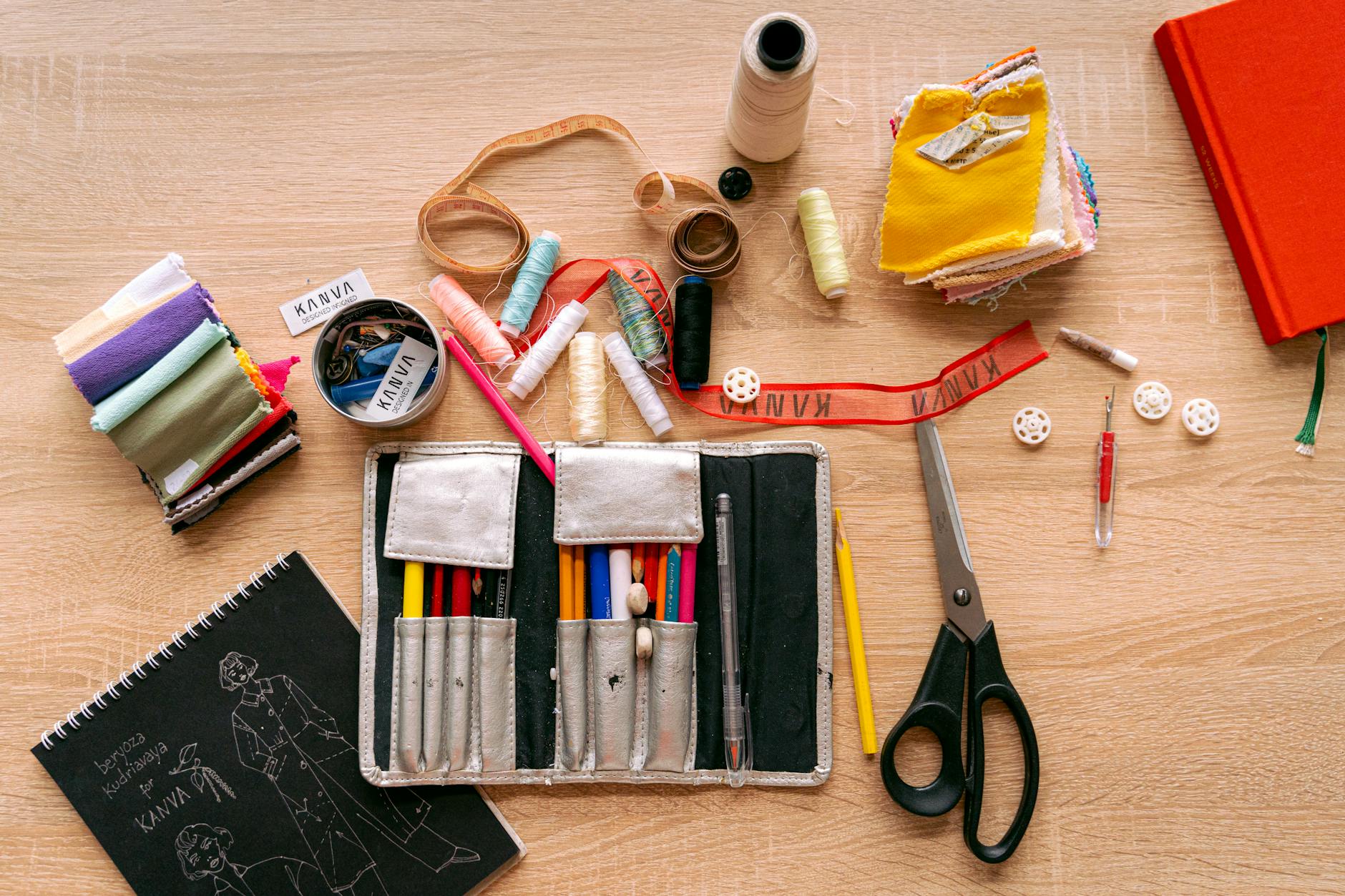 Flat lay of a sewing kit with threads, scissors, and fabric for creative crafting.