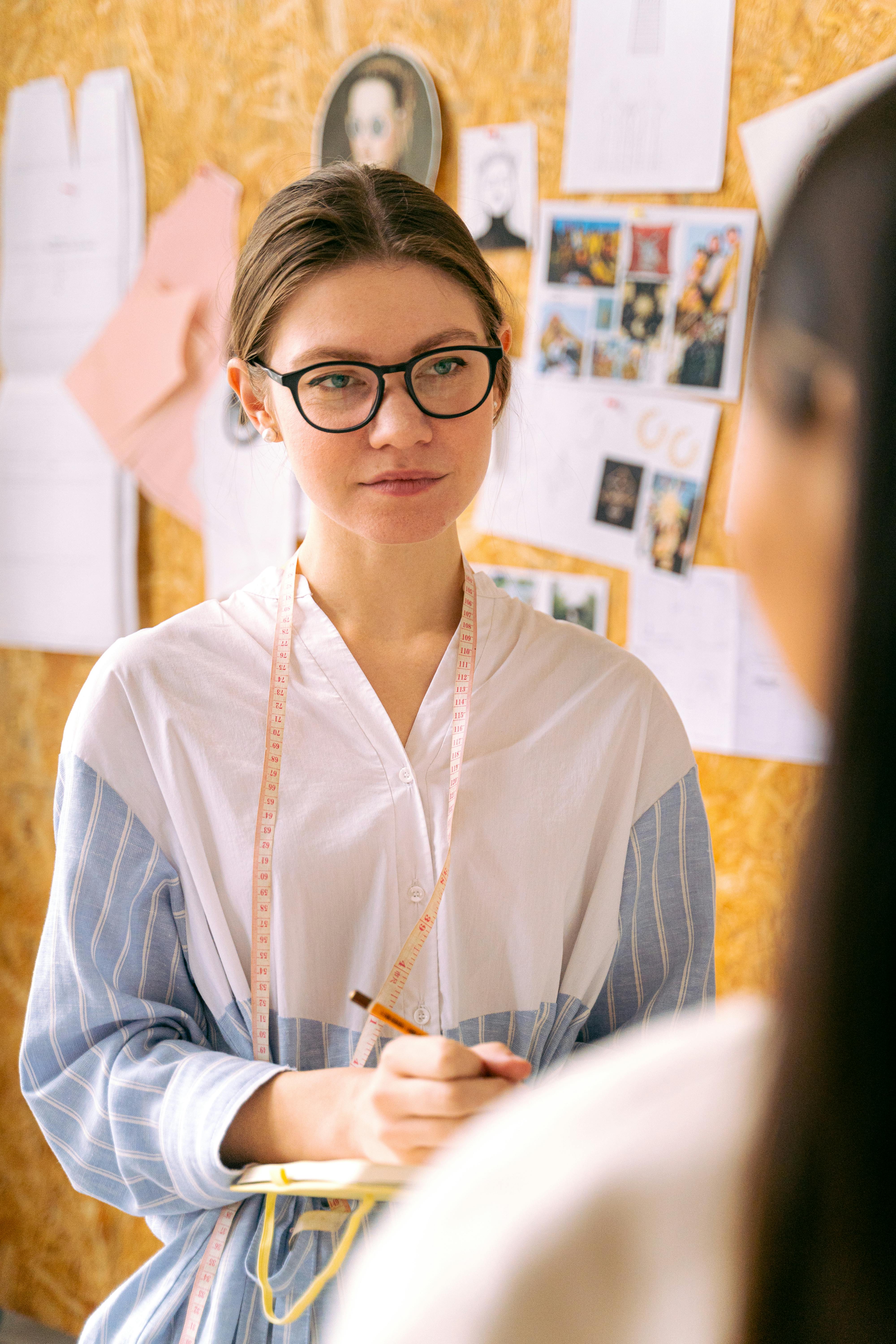 a woman with a measuring tape around her neck wearing eyeglasses