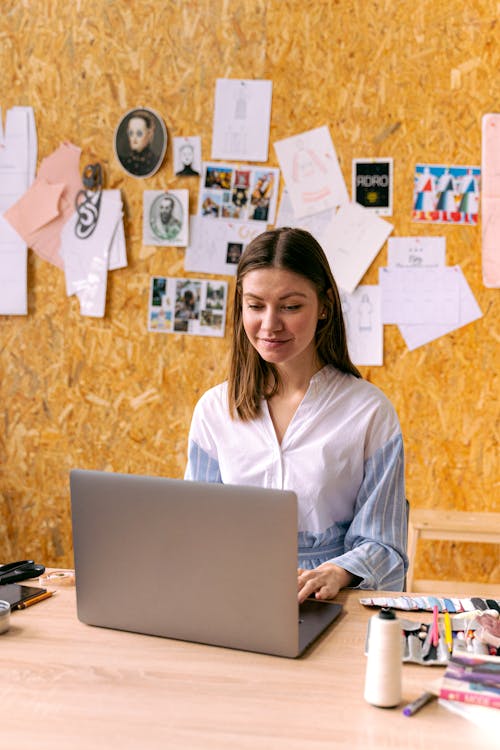 Woman in White and Blue Dress Shirt Using Silver Laptop 