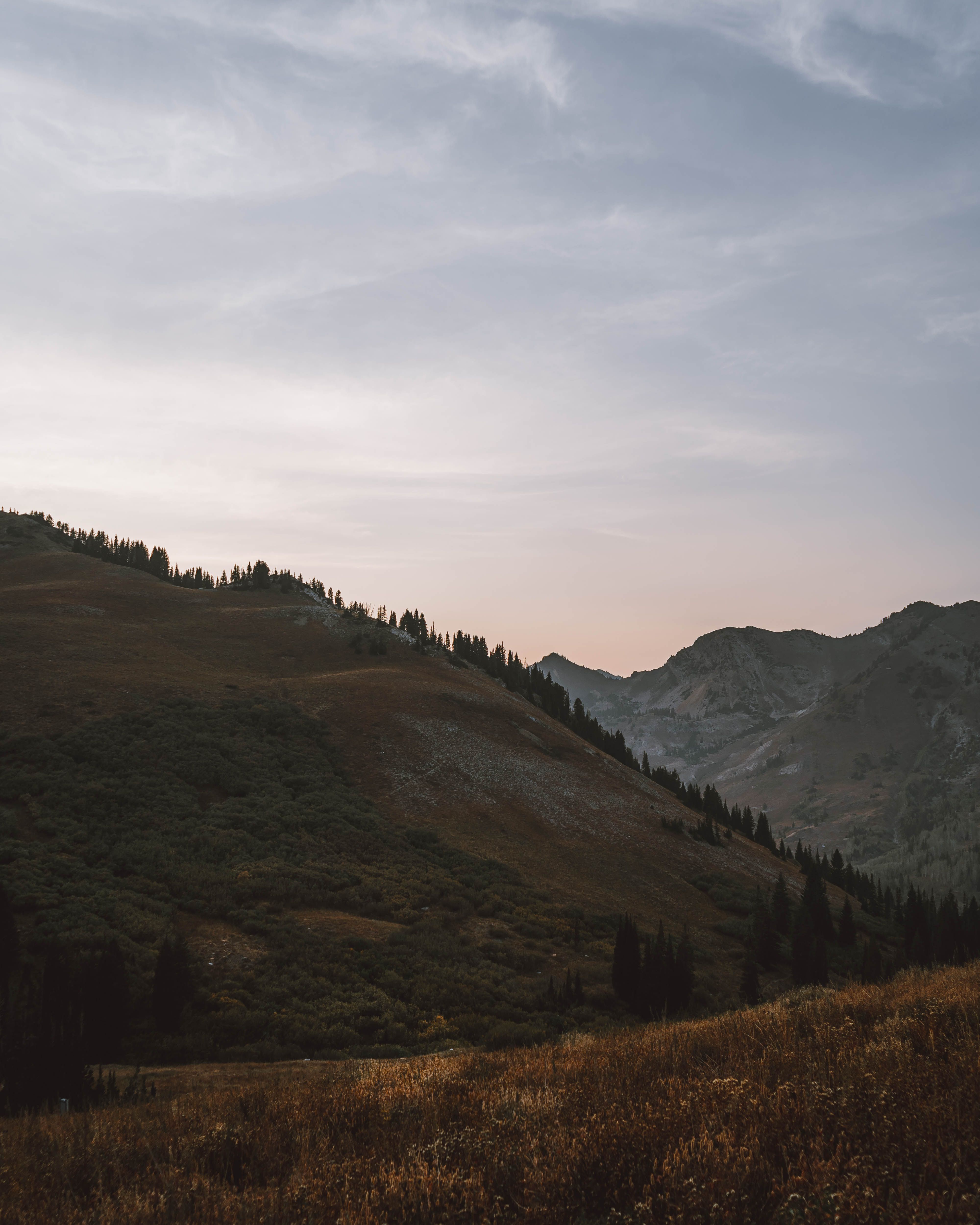 Peaceful mountainous landscape at twilight with rolling hills and serene sky.