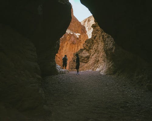 People Exploring a Cave in a Canyon 