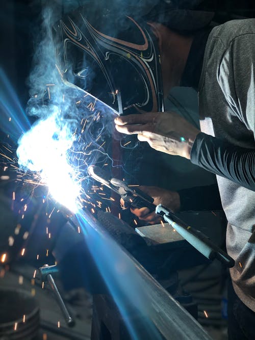 Person Wearing Black Welding Mask while Working