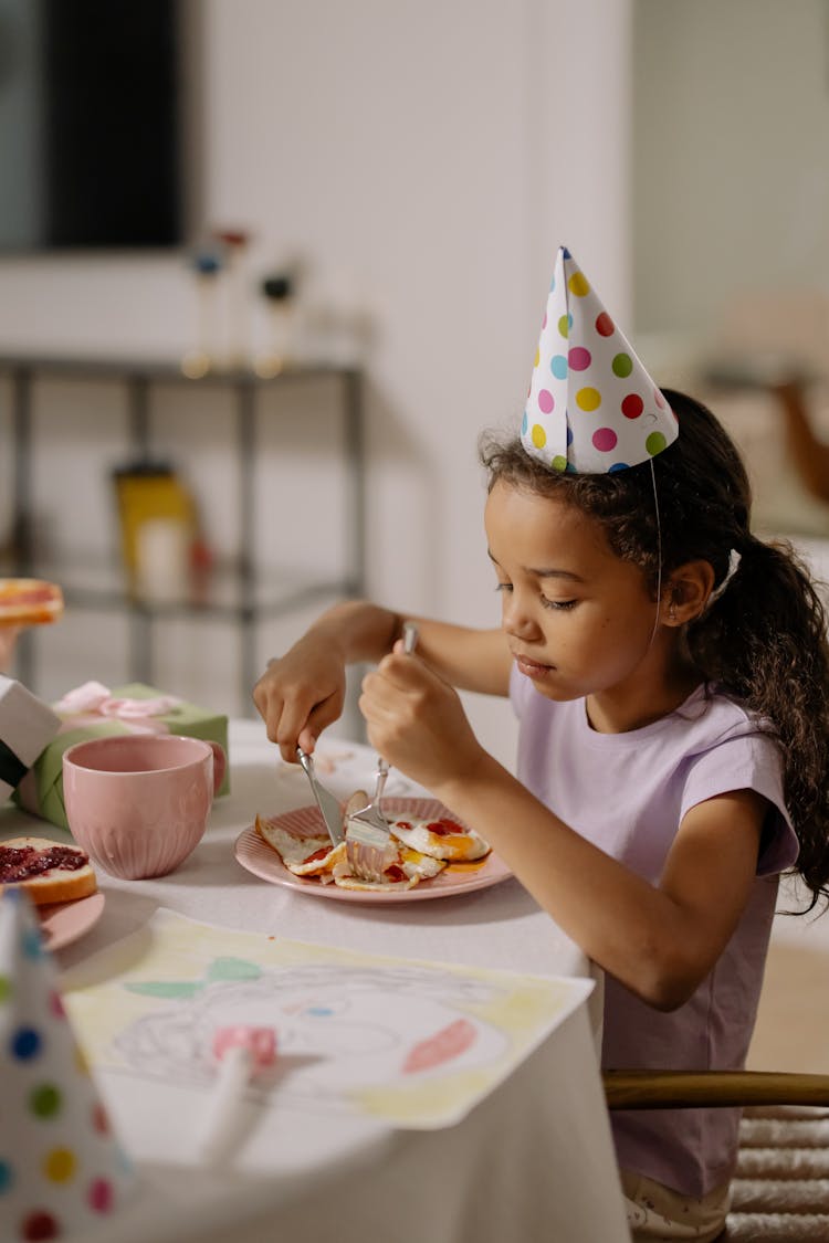 Girl In Purple T Shirt Wearing Party Hat Eating Eggs 