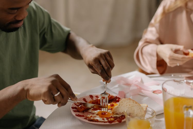 Man In Green Crew Neck T Shirt Using Knife And Fork