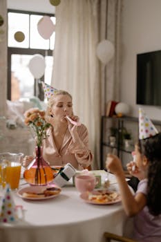 Joyful birthday scene with adults and children in party hats enjoying food and decorations.