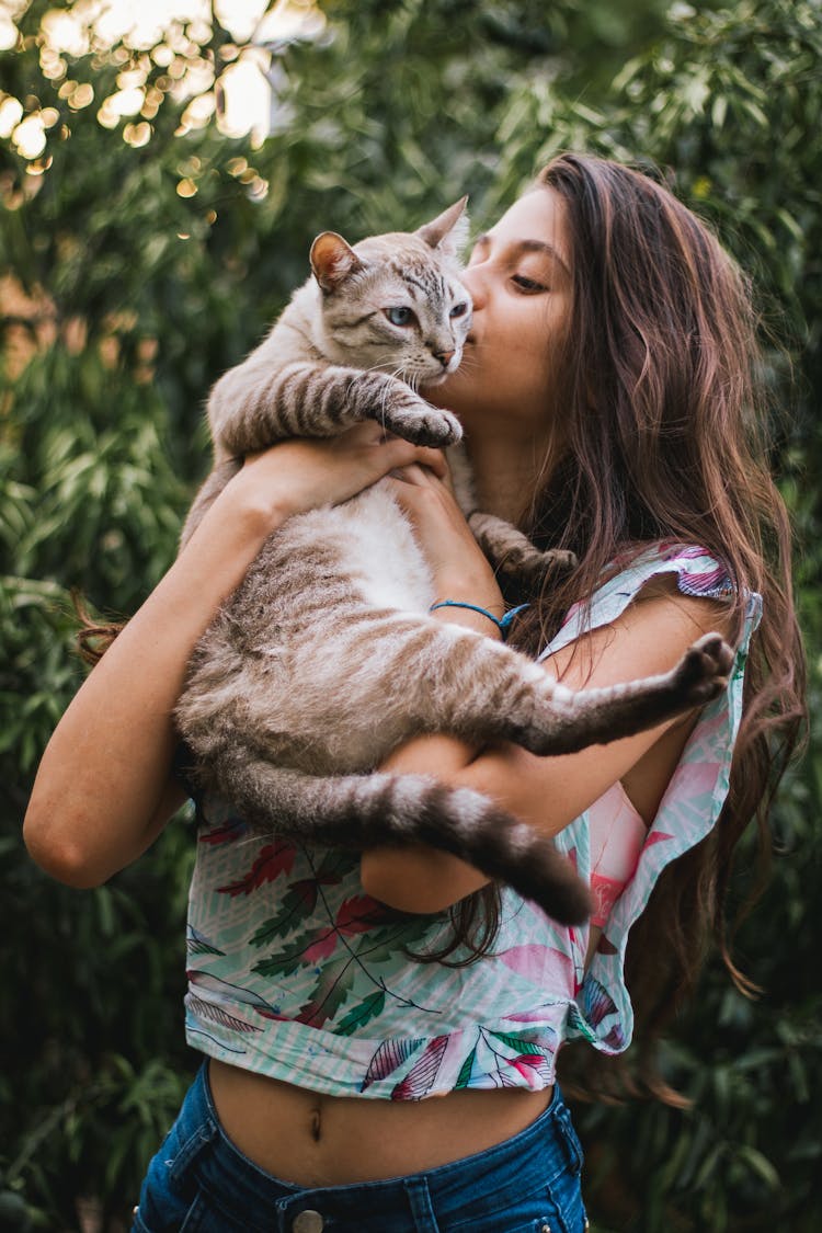 Photograph Of A Woman Kissing A Tabby Cat