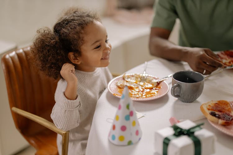 Girl In White Long Sleeve Shirt Eating Eggs