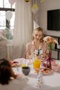 Woman in Pink Long Sleeve Shirt Sitting on Chair in Front of Table With Foods