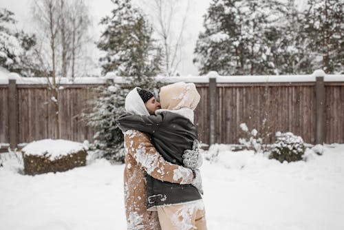 A Couple in Winter Clothes Embracing Each Other