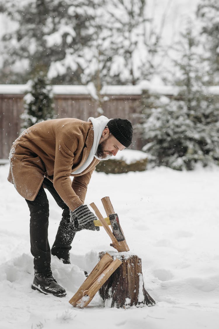 Man Chopping Wooden Logs With An Axe