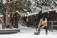Man in Red Jacket and Black Pants Playing on Snow Covered Ground