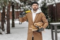 Man in Brown Coat Holding Ice Cream Cone