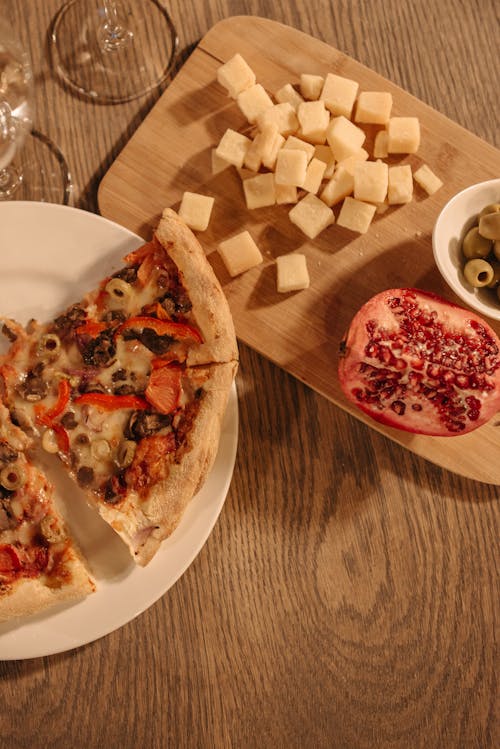 A Pizza on White Ceramic Plate Near the Cheese on Wooden Board