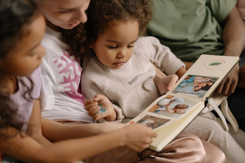 A mother and her daughters looking at a photo album