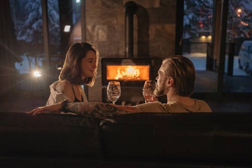 Free Photograph of a Couple Looking at Each Other While Holding Glasses of Wine Stock Photo