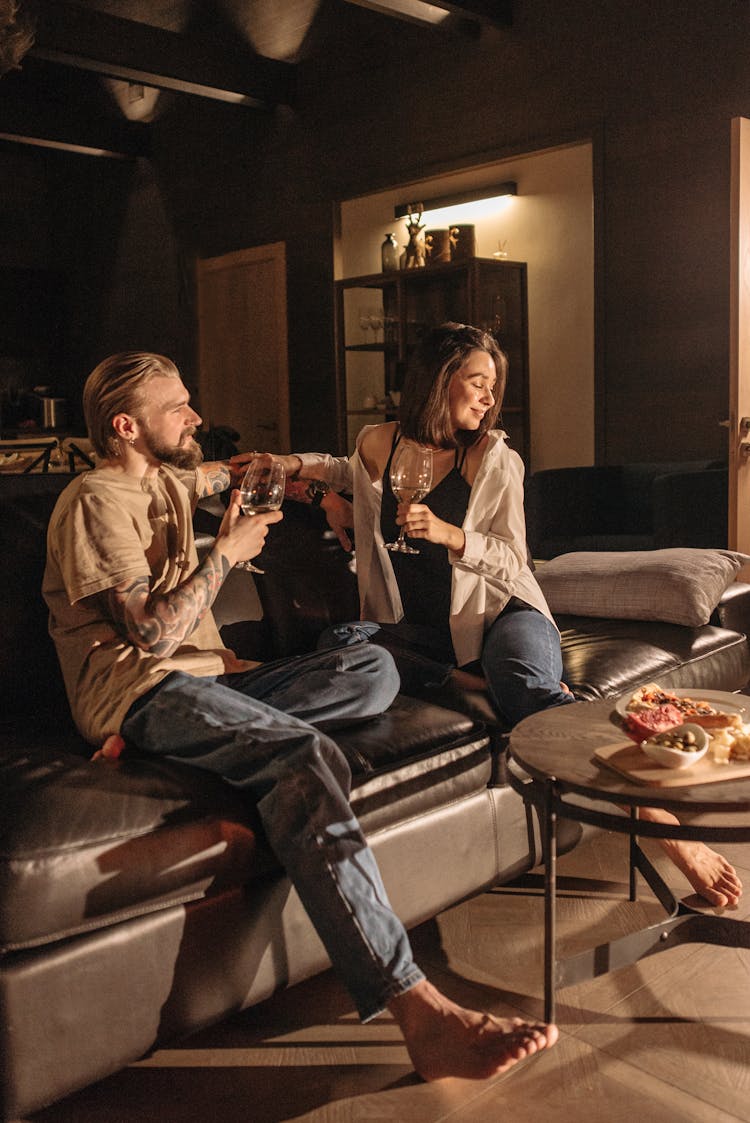 Couple Drinking Wine While Sitting On A Sofa