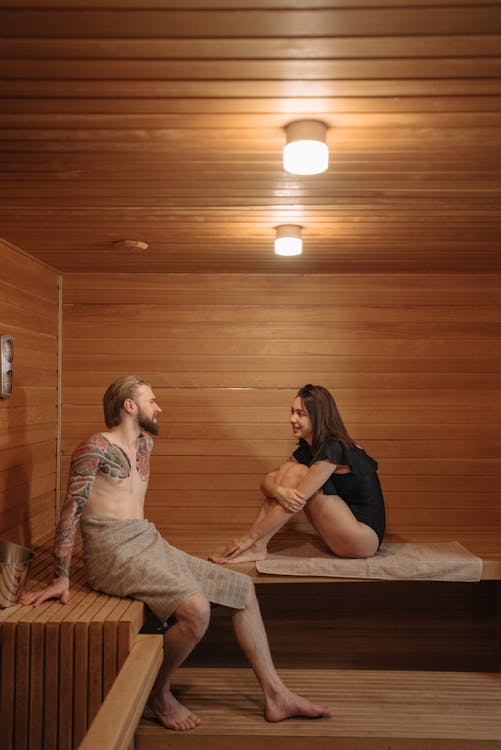 Free Couple Sitting on a Bench Inside the Sauna Stock Photo