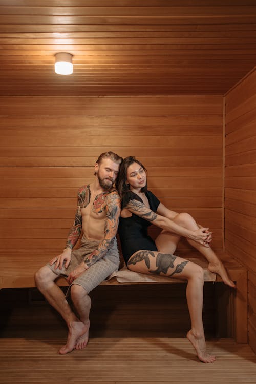 Man and Woman Sitting on Brown Wooden Bench