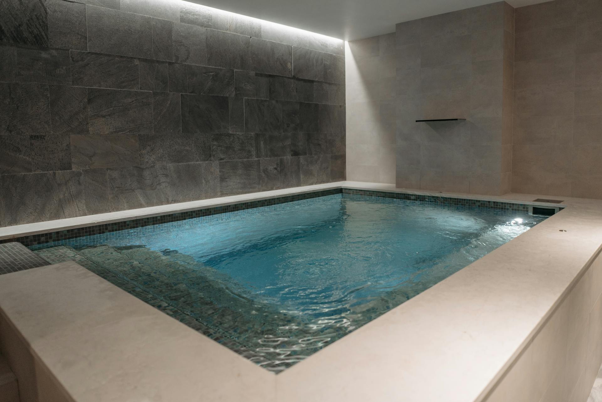 Blue Swimming Pool Near Gray Concrete Wall