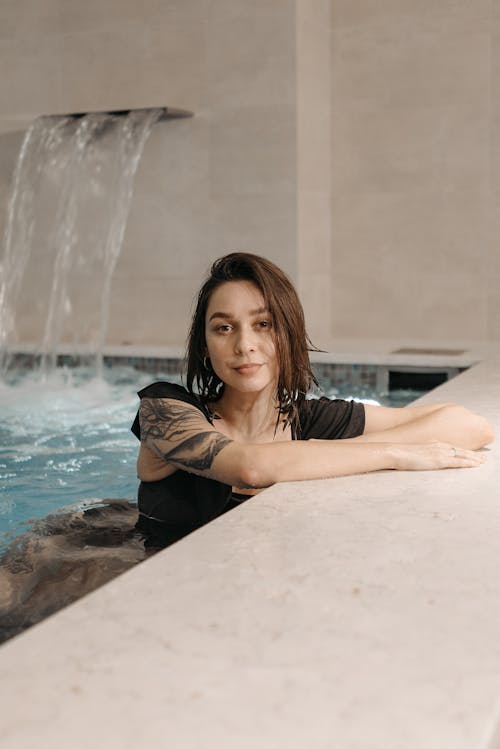 Photograph of a Woman in a Swimming Pool Wearing a Black Top