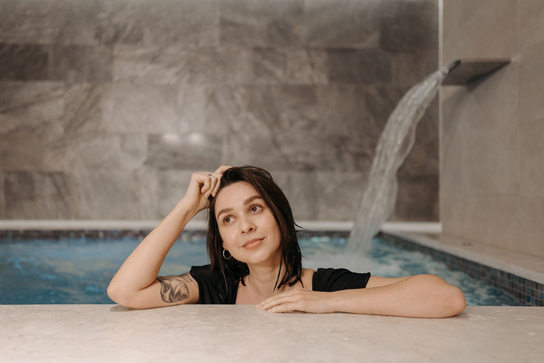 A woman rests by an indoor pool, a quieter image for the gap between feeling restored and promising too much in the language of recovery.