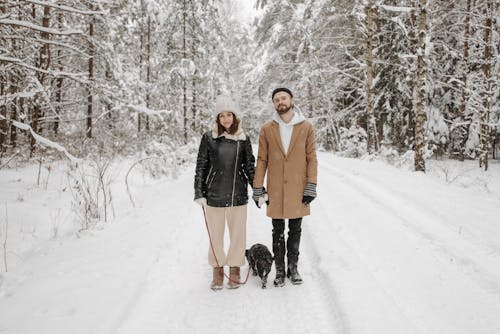 A Couple on a Snow Covered Pathway Holding Hands