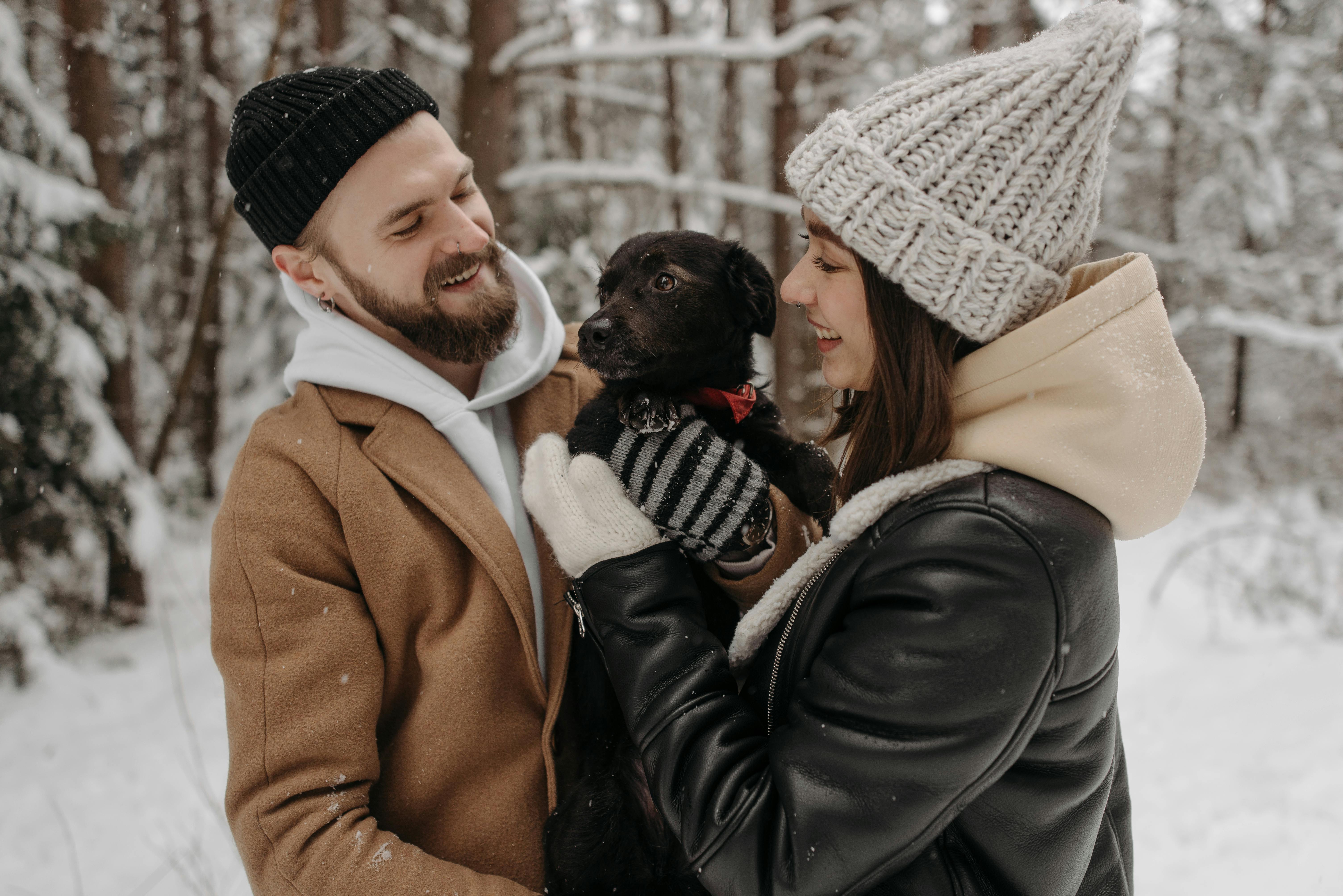 Photograph of a Couple Playing with Their Black Dog